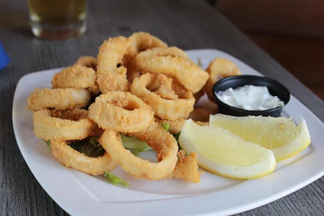 calamares con limón, salsa y lechuga